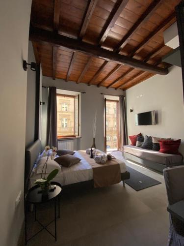 a bedroom with a large bed and a couch at Soha Piazza Di Spagna Boutique in Rome
