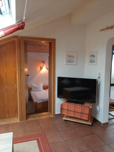 a living room with a large television and a bedroom at Ferienwohnung Evangeline Borsch in Zell an der Mosel