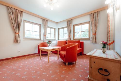 a waiting room with red chairs and a table at Dandler - Zimmer und Ferienwohnungen in Fieberbrunn