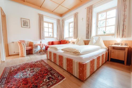 a bedroom with a large bed in a room with windows at Dandler - Zimmer und Ferienwohnungen in Fieberbrunn