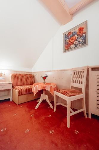 a living room with a couch and a table at Dandler - Zimmer und Ferienwohnungen in Fieberbrunn