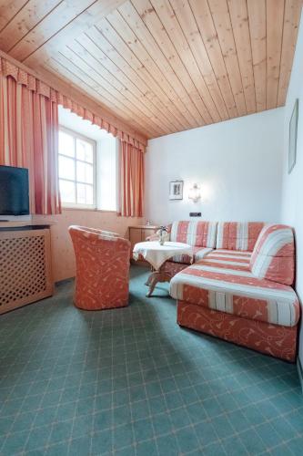 a hotel room with a bed and a tv at Dandler - Zimmer und Ferienwohnungen in Fieberbrunn