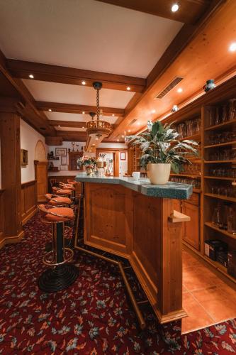 a bar in a room with a bunch of stools at Dandler - Zimmer und Ferienwohnungen in Fieberbrunn