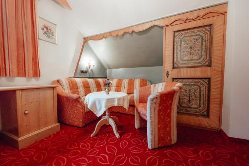 a room with a table and two chairs and a table at Dandler - Zimmer und Ferienwohnungen in Fieberbrunn
