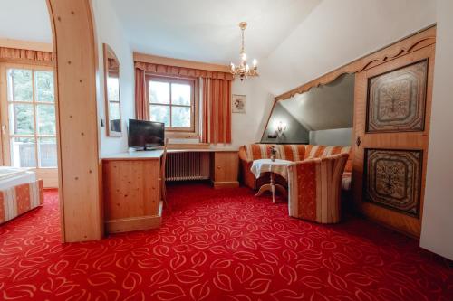 a hotel room with a red carpet at Dandler - Zimmer und Ferienwohnungen in Fieberbrunn
