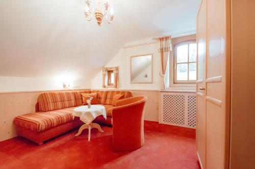 a living room with a couch and a table at Dandler - Zimmer und Ferienwohnungen in Fieberbrunn
