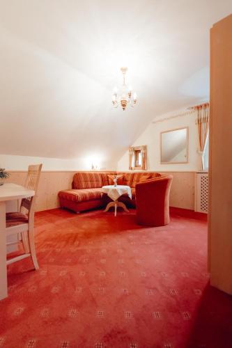 a living room with a couch and a table at Dandler - Zimmer und Ferienwohnungen in Fieberbrunn