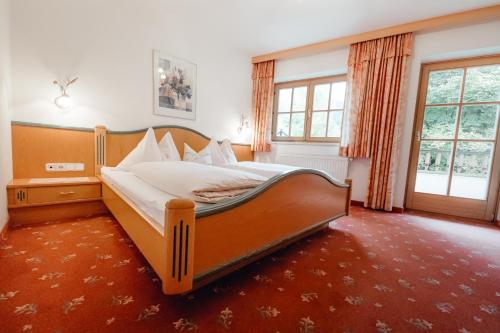 a bedroom with a large bed in a room at Dandler - Zimmer und Ferienwohnungen in Fieberbrunn