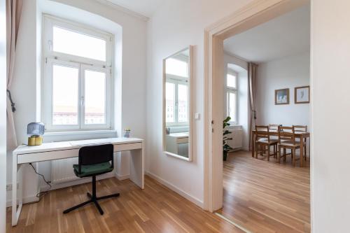 een witte kamer met een bureau en een stoel bij Central Apartment in Wenen