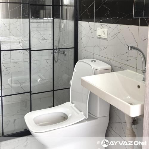 a bathroom with a white toilet and a sink at Ayvaz Otel in Torbalı
