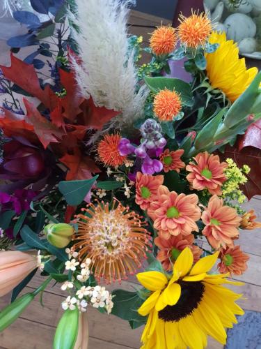 a bouquet of colorful flowers on a wooden table at B&B Le Jardin in Pelt