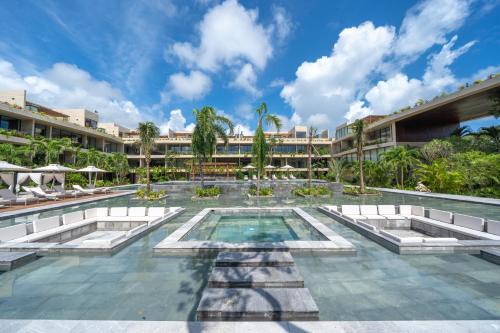 a resort swimming pool with a resort in the background at Mistiq Tulum in Tulum