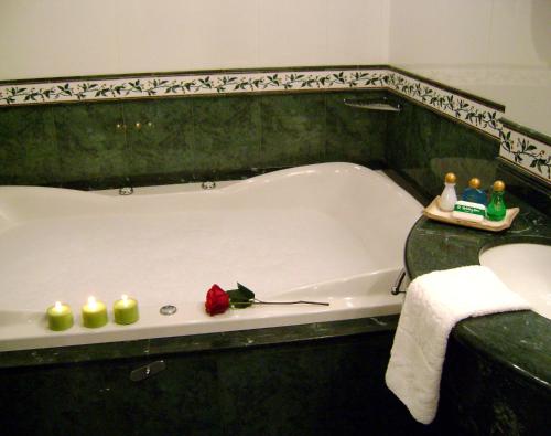 La salle de bains est pourvue d'une baignoire avec des bougies. dans l'établissement InterTower Hotel, à Santa Fe