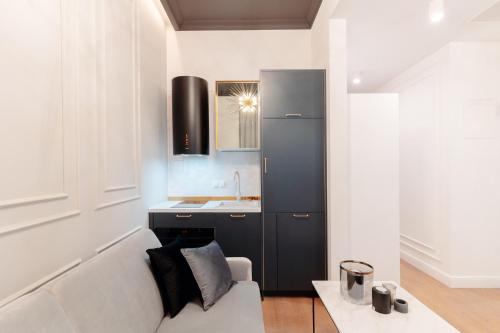 a kitchen with a couch and a sink in a room at Warsaw Story - LoftAffair Collection in Warsaw