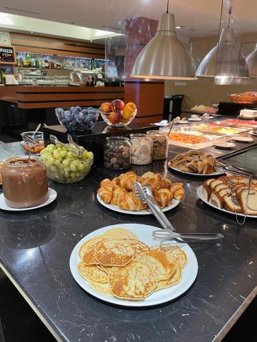 een buffet met schalen vol pannenkoeken en ander eten bij Saint George Palace Deluxe Collection in Bansko