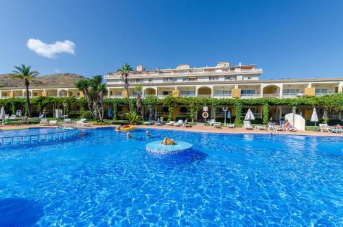 a large swimming pool with two people in a pool at Mariner Club in Port d'Alcudia