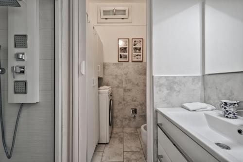 a white bathroom with a sink and a toilet at Casa LENA by Apartments To Art in Turin
