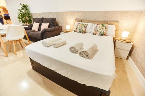 セビリアにあるCharming House - Calm and comfort in the centerのベッドルーム1室(大きな白いベッド1台、タオル付)