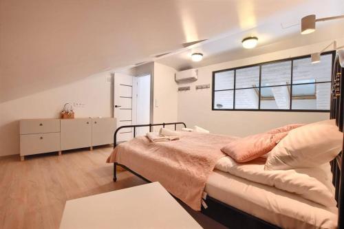 Un dormitorio con una cama grande y una ventana en Sun&Sport Apartamenty CEDROWY i ABIES parking i prywatna sauna w cenie, en Szczyrk