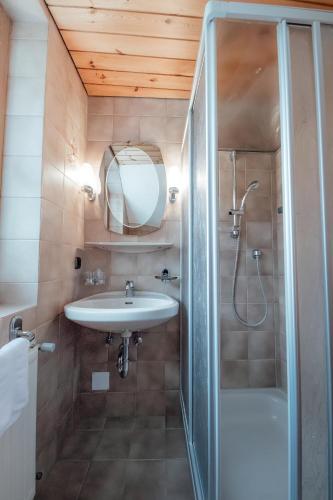 a bathroom with a sink and a shower at Dandler - Zimmer und Ferienwohnungen in Fieberbrunn