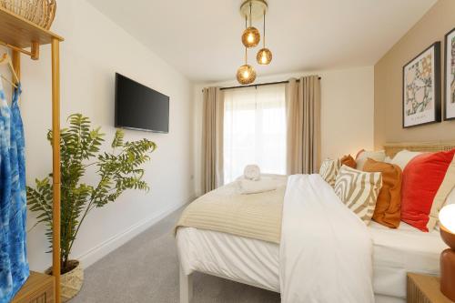 a bedroom with a bed and a tv on the wall at Alba - 2 Bedroom Luxury Apartment by Mint Stays in Bristol