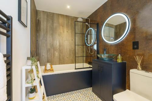 a bathroom with a tub and a sink and a mirror at Alba - 2 Bedroom Luxury Apartment by Mint Stays in Bristol