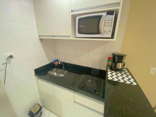 a small kitchen with a sink and a microwave at Flat Bienal Ibirapuera c/ Sacada UH 1107 in Sao Paulo