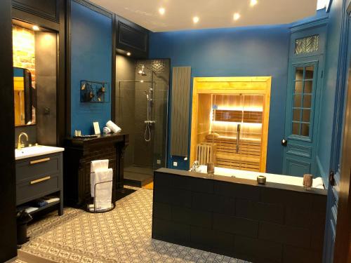 une salle de bain bleue avec une douche et un lavabo dans l'établissement Le Ba Roc, à Calais