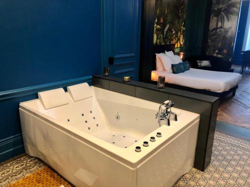 a large bath tub in a room with a bed at Le Ba Roc in Calais