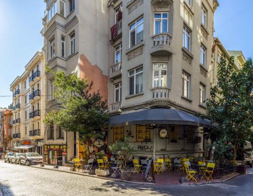 um edifício com mesas e cadeiras amarelas numa rua em Monnas Suite em Istambul