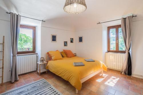 une chambre avec un lit avec une couverture jaune dans l'établissement Le Domaine Morleau, à Lablachère