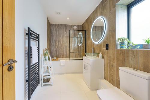 bagno con servizi igienici, lavandino e specchio di Honeysuckle - 1 Bedroom Luxury Apartment by Mint Stays a Bristol