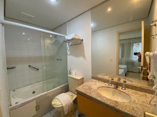 a bathroom with a sink and a shower and a toilet at Flat Bienal Ibirapuera UH507 in Sao Paulo