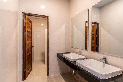 a bathroom with two sinks and a mirror at Villa Pitak Private Pool Villa Khaoyai in Ban Khanong Phra Nua