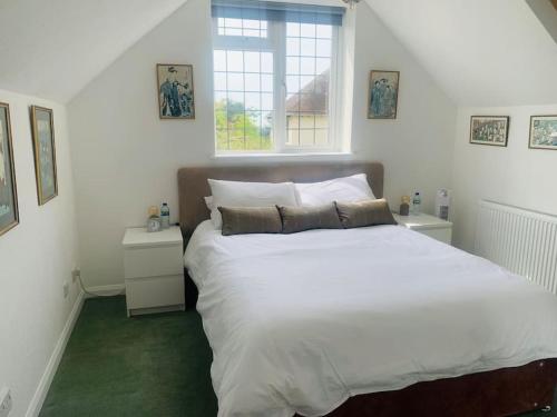 a bedroom with a large white bed and a window at La Mer in Ferring