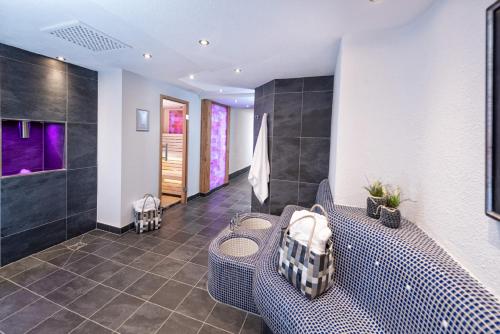 a bathroom with a bench and a shower with purple lights at Concordia Vitalhotel & SPA in Oberstaufen