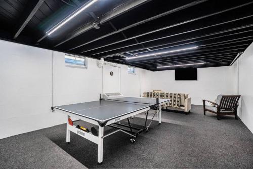 a ping pong table in a room with a tv at The Wendover - Entire Home near Lake Michigan! in Norton Shores