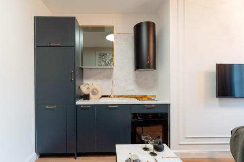 a kitchen with blue cabinets and a sink at Warsaw Story - LoftAffair Collection in Warsaw