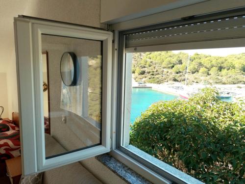 a window with a view of a swimming pool at Apartments Uvala Murtar in Jezera