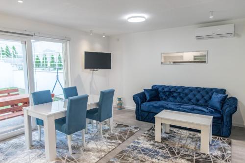 ein Wohnzimmer mit einem blauen Sofa, einem Tisch und Stühlen in der Unterkunft Villa Noor in Sarajevo
