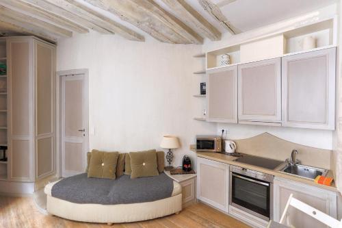 - une cuisine avec un lit dans l'angle d'une pièce dans l'établissement Louvre Charmant Studio, à Paris