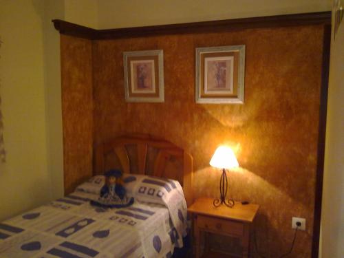 een slaapkamer met een bed en een lamp op een tafel bij Candelario in Candelario