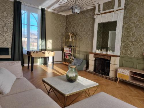 a living room with a couch and a table at Presbytère avec piscine chauffée in Bosc-Geffroy