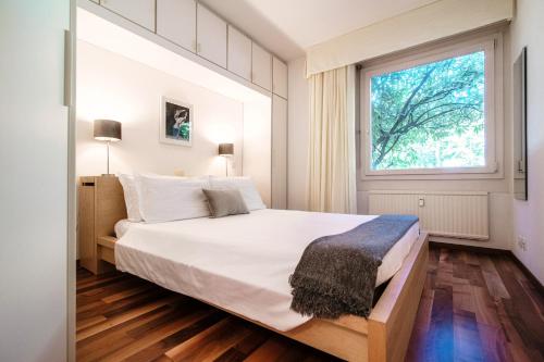 Un dormitorio con una cama grande y una ventana en Cadro Garden by Quokka 360 - flat with garden view, en Lugano