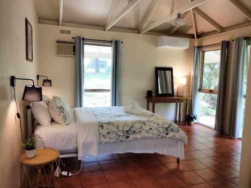 a bedroom with a bed and a couch at Kalimna Woods Cottages in Lakes Entrance