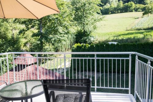 a table and chairs on a balcony with an umbrella at Villa Noor in Sarajevo