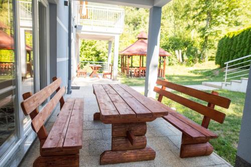 two wooden benches sitting on a porch with a gazebo at Villa Noor in Sarajevo