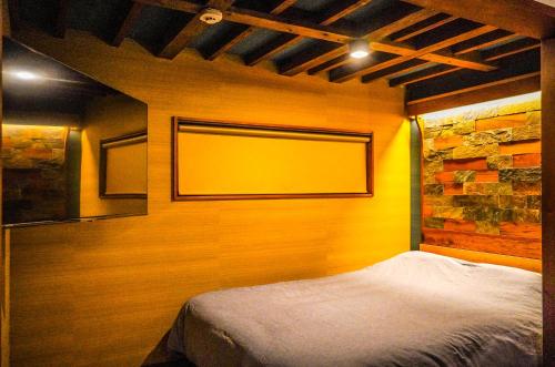 a bedroom with a bed with a yellow wall at Nikko Cottage Yurt in Nikko