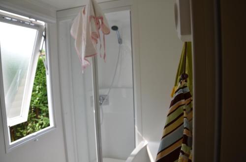 een badkamer met een douche en een glazen deur bij Happy Camp mobile homes in Villaggio Turistico Internazionale Eden in San Felice del Benaco