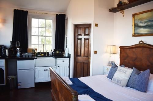 a bedroom with a bed and a kitchen with a window at The West Usk Lighthouse Lightkeepers Lodge in Newport